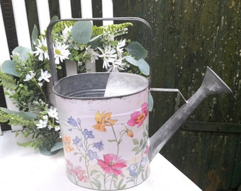 Decorative watering can in vintage style with flowers garden decoration