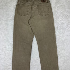 Op de afbeelding: Een paar bruine Wrangler jeans met een rechte pijp.