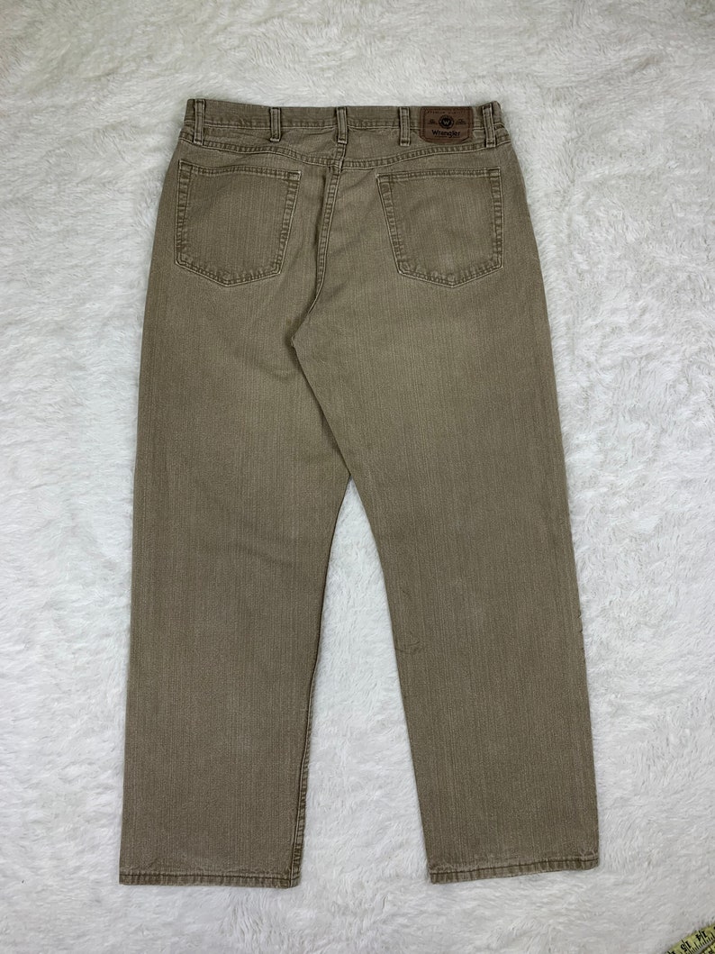 Op de afbeelding: Een paar bruine Wrangler jeans met een rechte pijp.
