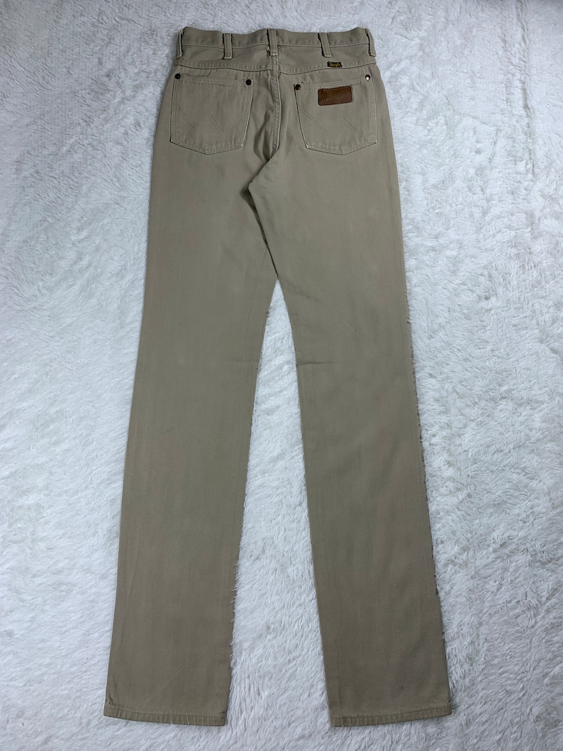 Op de afbeelding: Een lichtbruine jeans met rechte pijpen en een bruin leren patch op de achterzak.