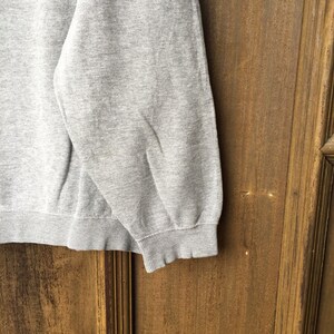 May include: A gray sweatshirt with a ribbed hem and cuffs.