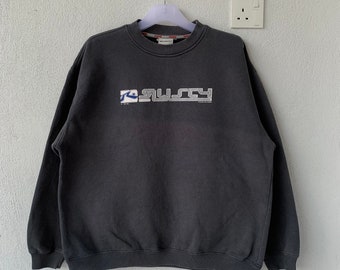 May include: A dark gray sweatshirt with a white "RUSH" logo featuring a blue wave graphic. The logo is embroidered on the front of the sweatshirt.