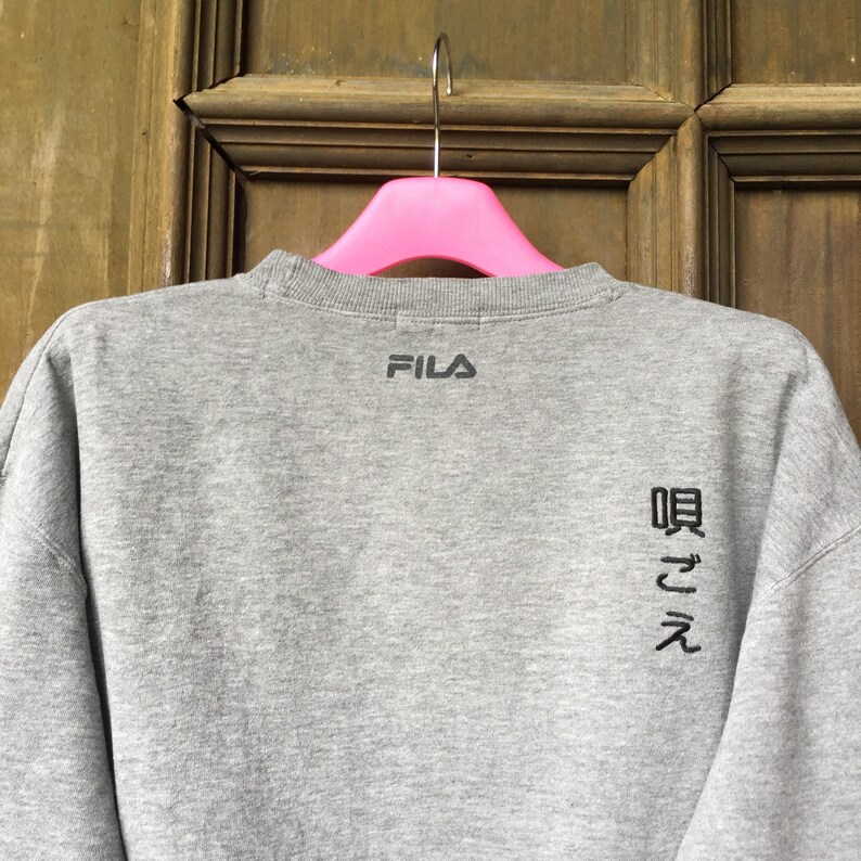 May include: Gray sweatshirt with the word "FILA" embroidered on the back, along with Japanese characters.
