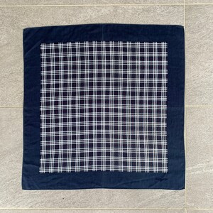May include: A navy blue bandana with a white and red plaid pattern. The bandana has a navy blue border and the text "The Gallery" in white lettering in the bottom right corner.