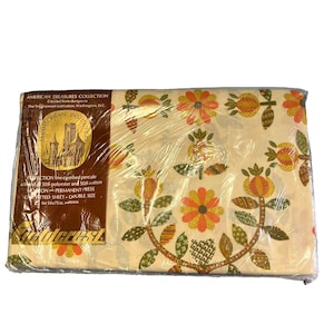 May include: A double-size fitted sheet from the American Treasures Collection. The sheet features a floral pattern in orange, yellow, and green on a cream background. The packaging includes text from the Smithsonian Institution.