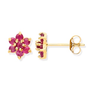 May include: A pair of gold earrings with a flower-shaped design featuring red ruby stones.