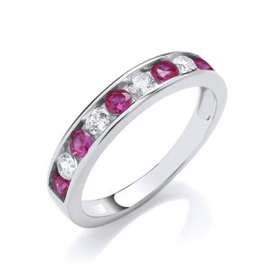 May include: A silver band ring with alternating pink ruby and clear round diamonds.