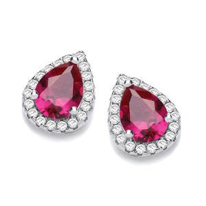 May include: A pair of silver earrings featuring a pear-shaped red gemstone set within a halo of smaller clear gemstones.