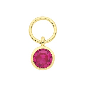 May include: A gold charm with a pink gemstone. The charm has a round loop at the top for attaching to a bracelet or necklace.