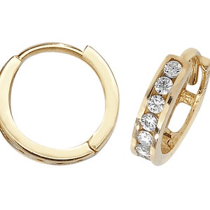 May include: A pair of gold hoop earrings with a single row of clear cubic zirconia stones.