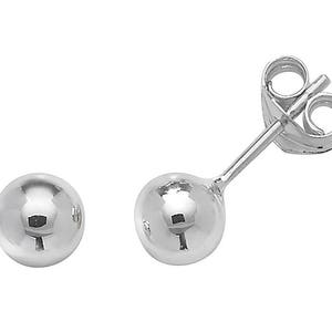May include: A pair of silver ball stud earrings.