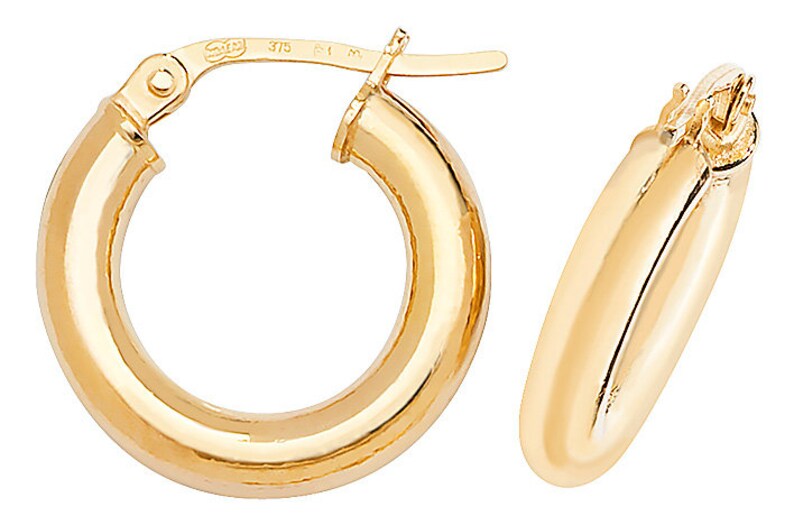 Puede incluir: Dos pendientes de aro dorados. Los pendientes tienen un dise&ntilde;o cl&aacute;sico, con una superficie redondeada y pulida. Los aros son de tama&ntilde;o mediano y tienen un cierre seguro. Est&aacute;n hechos de un material de oro amarillo brillante.