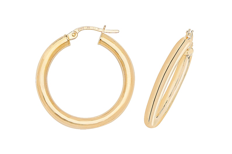 Puede incluir: Dos pendientes de aro dorados. Los pendientes tienen un dise&ntilde;o redondo cl&aacute;sico con un acabado pulido. Los aros son de tama&ntilde;o mediano y tienen un estilo simple y elegante. Los pendientes se muestran sobre un fondo blanco.