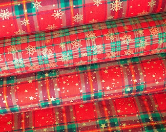 Può includere: Tre rotoli di tessuto a quadri rosso e verde con motivi di fiocchi di neve e stelle dorate. Il tessuto è perfetto per lavori artigianali e progetti natalizi.