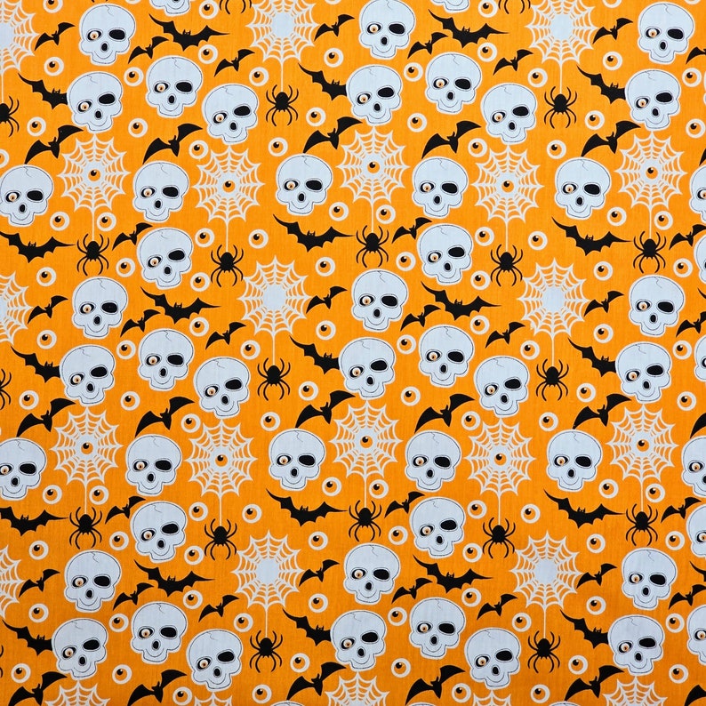 May include: Orange fabric with a repeating pattern of white spiderwebs, black bats, and white skulls with black eyes. The background is a solid orange color.