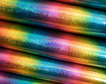 Op de afbeelding: Close-up van iriserende regenboog glitterstof, opgerold in meerdere lagen, toont de textuur en kleurvariaties.