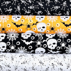 May include: Four rolls of Halloween-themed fabric featuring different patterns. The top roll has a black background with white skeletons. The second roll has a yellow background with white skulls, bats, spiders, and eyes. The third roll has a black background with white skulls, bats, spiders, and eyes. The bottom roll has a white background with black skeletons.