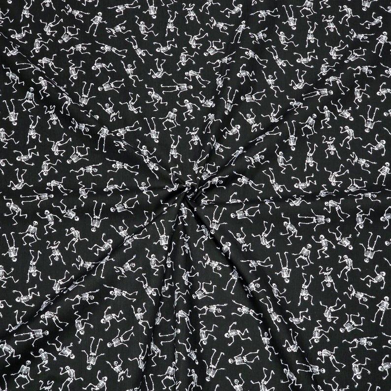 May include: Black fabric with a white skeleton pattern. The skeletons are dancing and are repeated throughout the fabric.