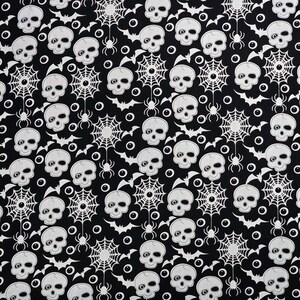 May include: Black and white fabric with a repeating pattern of skulls, spiderwebs, bats, and eyeballs.