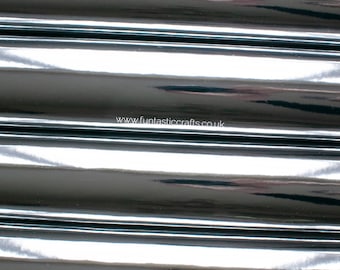 Op de afbeelding: Close-up van zwart vinylweefsel met een glanzend, reflecterend oppervlak. De stof is gevouwen in een reeks parallelle lijnen, waardoor een gestreept patroon ontstaat. Het websiteadres "www.fantasticcrafts.co.uk" is op de stof gedrukt.