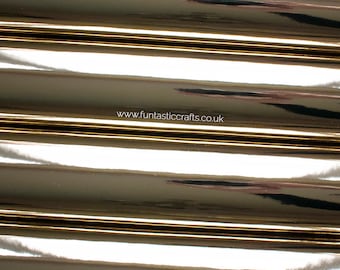 Op de afbeelding: Close-up van verschillende rollen glanzende, metallic gouden folie. De folie heeft een reflecterend oppervlak en is gerangschikt in parallelle lijnen. Het websiteadres "www.funtasticcrafts.co.uk" is zichtbaar.