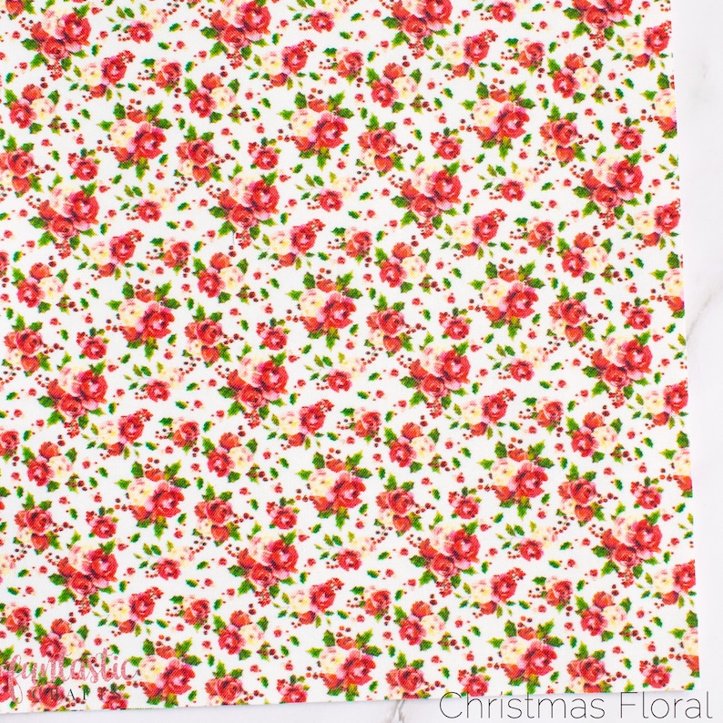 May include: White fabric with a repeating pattern of red and white roses, green leaves, and red berries. The fabric has the text "Christmas Floral" printed at the bottom.