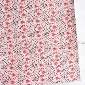 Puede incluir: Una tela rosa y marrón con un patrón repetido de rosas rosas y manchas de leopardo marrones.