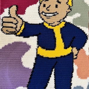 May include: A crocheted blanket featuring the Vault Boy character from the Fallout video game series. The character is shown giving a thumbs-up, wearing a blue jumpsuit with yellow details. The background has a colourful camouflage pattern.