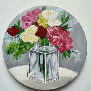 May include: A painting of a bouquet of pink, white, and red flowers in a clear glass vase on a gray background.
