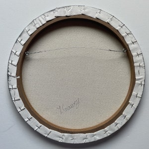 May include: The back of a round canvas painting with a wooden frame. The canvas is white and has a signature in black ink that reads "Y. Gauvey".