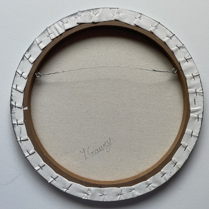 May include: The back of a round canvas painting with a wooden frame. The canvas is white and has a signature in black ink that reads "Y. Gauvey".