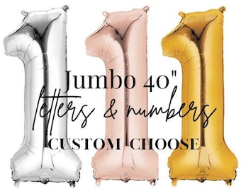 May include: Three metallic number one balloons in silver, rose gold, and gold. The balloons are 40 inches tall. Text on the image reads "Jumbo 40" letters & numbers CUSTOM CHOOSE."