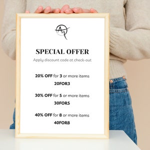 May include: A framed sign with the text "SPECIAL OFFER" and discount details. The sign is held by a person. The text includes "20% OFF for 3 or more items", "30% OFF for 5 or more items", and "40% OFF for 8 or more items".