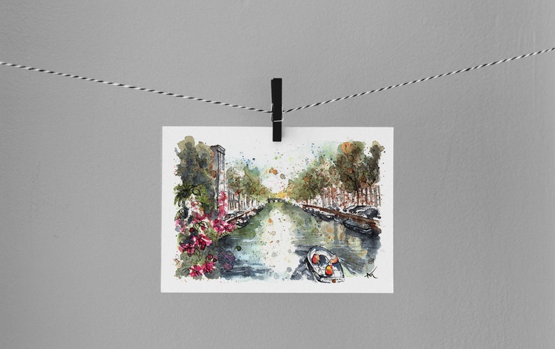 May include: Watercolor painting of a canal in a city with buildings on either side. The canal is lined with trees and there is a small boat in the water. The painting is done in a loose, impressionistic style.