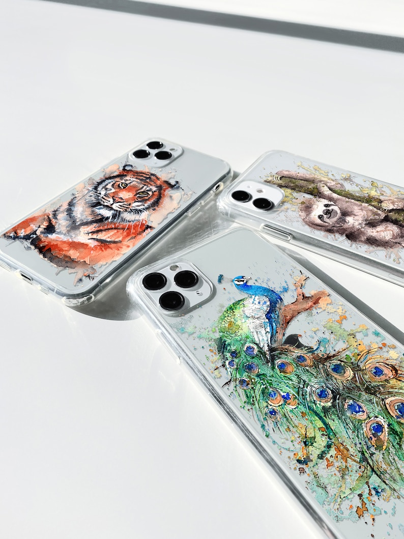 May include: Three clear phone cases with different animal designs. The first case features a tiger, the second case features a sloth, and the third case features a peacock.