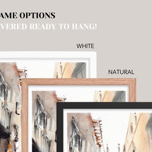 May include: Watercolor art print with three frame options: white, natural, and black. The artwork depicts a street scene with buildings in shades of gray, brown, and orange. Text at the top reads "3 FRAME OPTIONS DELIVERED READY TO HANG!"