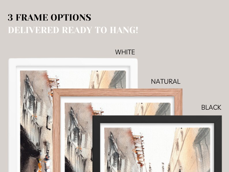 May include: Watercolor art print with three frame options: white, natural, and black. The artwork depicts a street scene with buildings in shades of gray, brown, and orange. Text at the top reads "3 FRAME OPTIONS DELIVERED READY TO HANG!"