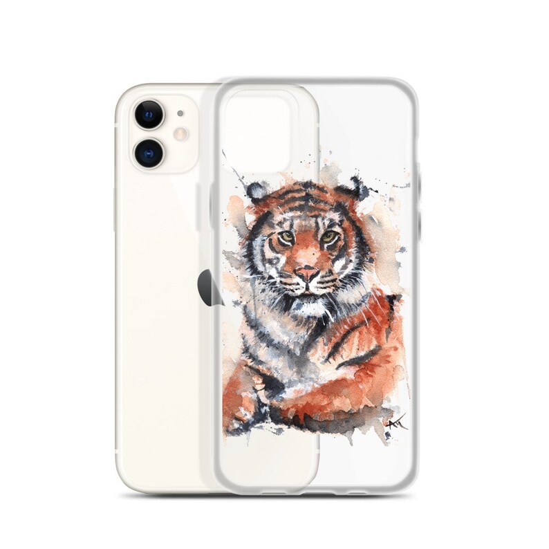 May include: A clear phone case with a watercolor illustration of a tiger. The tiger is sitting with its head turned to the side and its eyes looking directly at the viewer. The background is a white watercolor wash with splashes of color.