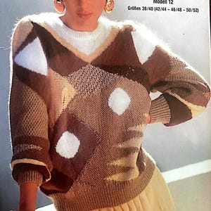 Könnte beinhalten: Ein brauner, weißer und beiger Strickpullover mit geometrischem Muster. Der Pullover hat einen Rundhalsausschnitt und lange Ärmel. Der Text "Modell 12" und "Größen 38/40 (42/44 - 46/48 - 50/52)" ist auf dem Bild gedruckt.