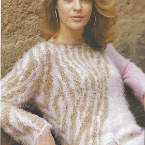 May include: A fuzzy pink and brown striped sweater with a flower-shaped belt buckle.