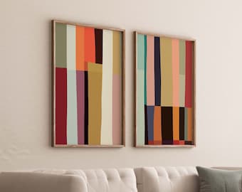 May include: Two framed abstract art prints with colorful geometric patterns in shades of red, orange, yellow, green, blue, and black. The prints are hung on a white wall above a white couch.