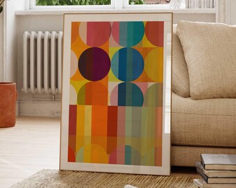 Puede incluir: Impresión de arte geométrico abstracto con un patrón colorido de círculos y cuadrados en tonos de amarillo, naranja, rojo, azul, verde y morado. La impresión está enmarcada en un marco de madera claro.