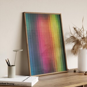 Op de afbeelding: Een ingelijste kunstdruk met een kleurrijk geometrisch ontwerp. Het kunstwerk toont een spectrum aan kleuren, van diepblauw tot heldergeel, gerangschikt in verticale rechthoekige blokken. De houten lijst voegt een natuurlijke toets toe aan het moderne kunstwerk.