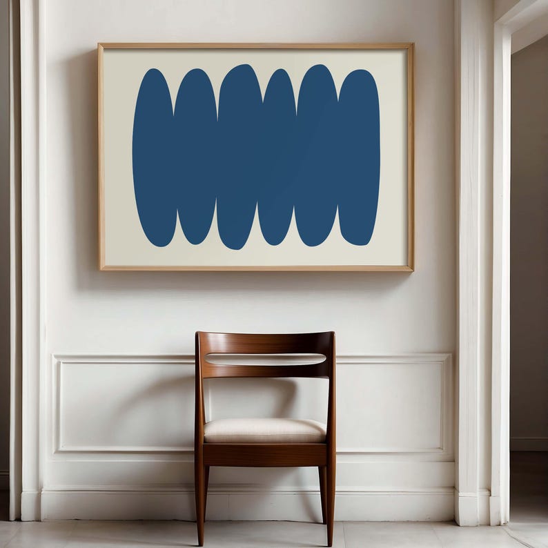 May include: A framed abstract print with a design of six overlapping blue ovals on a cream background.