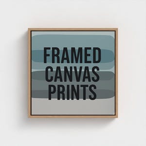 May include: A framed canvas print with a wooden frame. The artwork features horizontal bands of blue, gray, and white. Bold black text reads "FRAMED CANVAS PRINTS". The artwork is displayed against a white background.