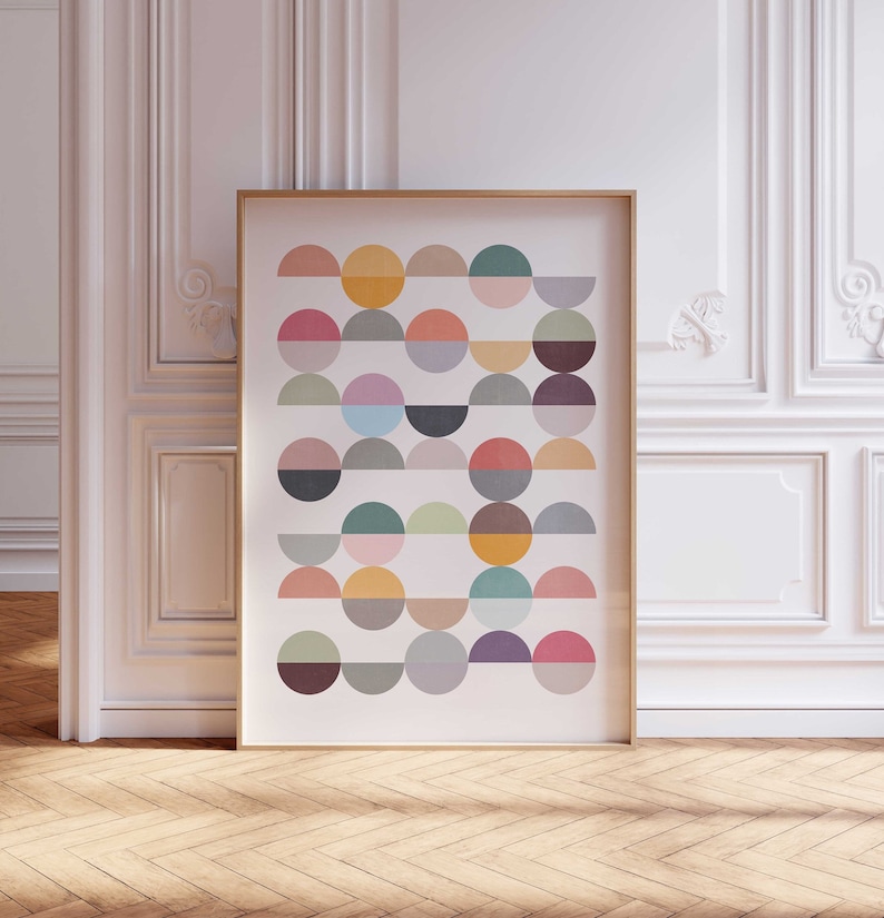 May include: A framed print with a geometric design of colorful semi-circles in various shades of pink, green, blue, yellow, orange, and brown.