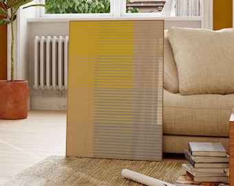 May include: A rectangular framed wall art print featuring a geometric pattern of horizontal lines in mustard yellow, light gray, and beige. The composition is divided into vertical sections with varying line densities, creating a layered visual effect.