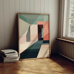 Könnte beinhalten: Ein gerahmter, abstrakter geometrischer Kunstdruck mit einem farbenfrohen Design in Türkis, Rosa und Beige. Das Kunstwerk lehnt an einer Wand, mit einem Stapel Bücher im Vordergrund. Der Druck ist in einem Holzrahmen.