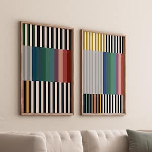 Könnte beinhalten: Zwei gerahmte abstrakte Kunstdrucke mit vertikalen Streifen in Schwarz, Weiß, Grau, Gelb, Rot, Grün und Blau. Die Drucke hängen an einer weißen Wand.
