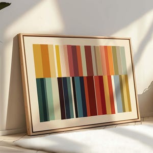 Puede incluir: Una impresi&oacute;n art&iacute;stica abstracta enmarcada con rayas verticales multicolores. La paleta de colores incluye amarillo, naranja, rojo, azul y verde. La obra de arte est&aacute; enmarcada en un marco de madera clara, contra una pared blanca.